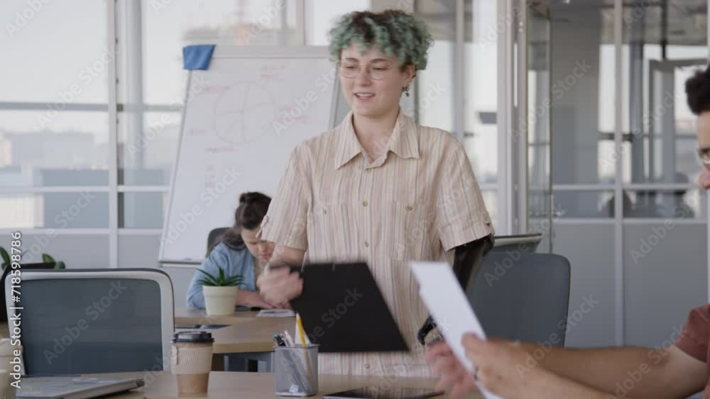 Medium shot of young Caucasian woman with artificial limb shaking hands to diverse co-workers after having successful negotiation meeting at table in conference room Medium shot of young Caucasian woman with artificial limb shaking hands to diverse co-workers after having successful negotiation meeting at table in conference room
