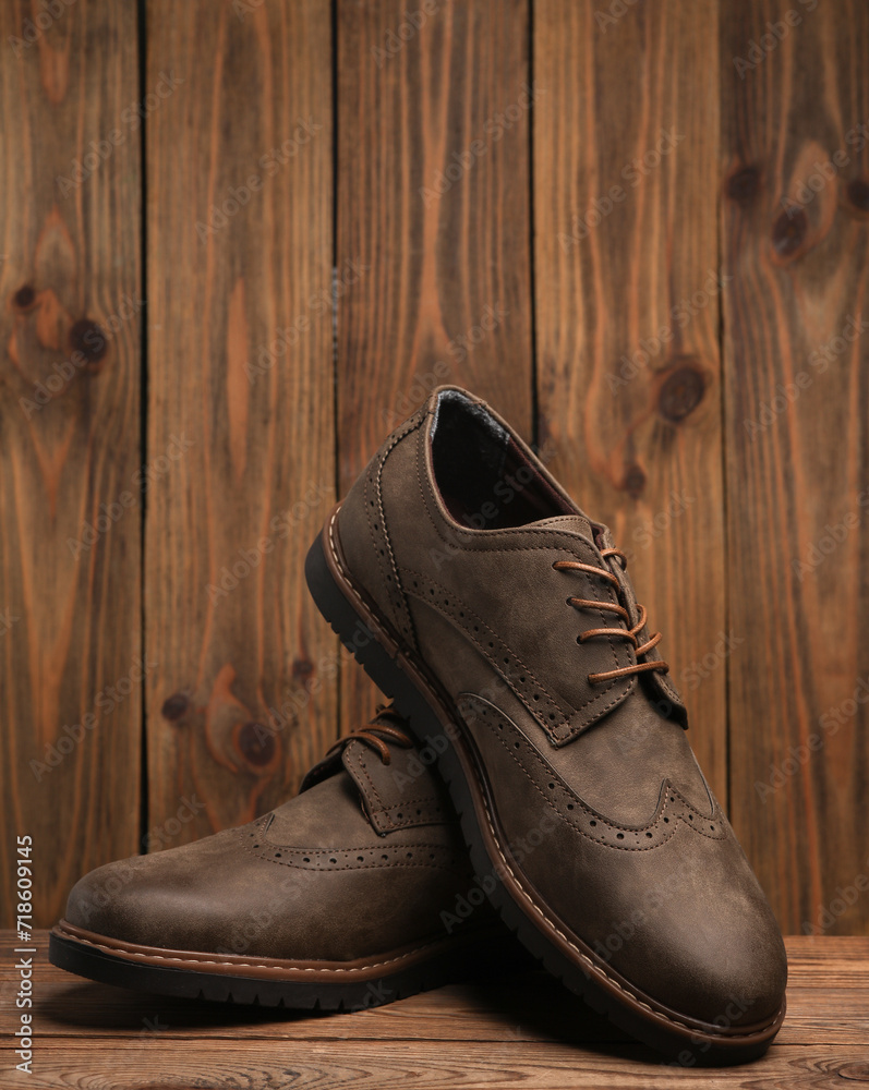 Pair of stylish men's brogue shoes on a wooden background Pair of stylish men's brogue shoes on a wooden background