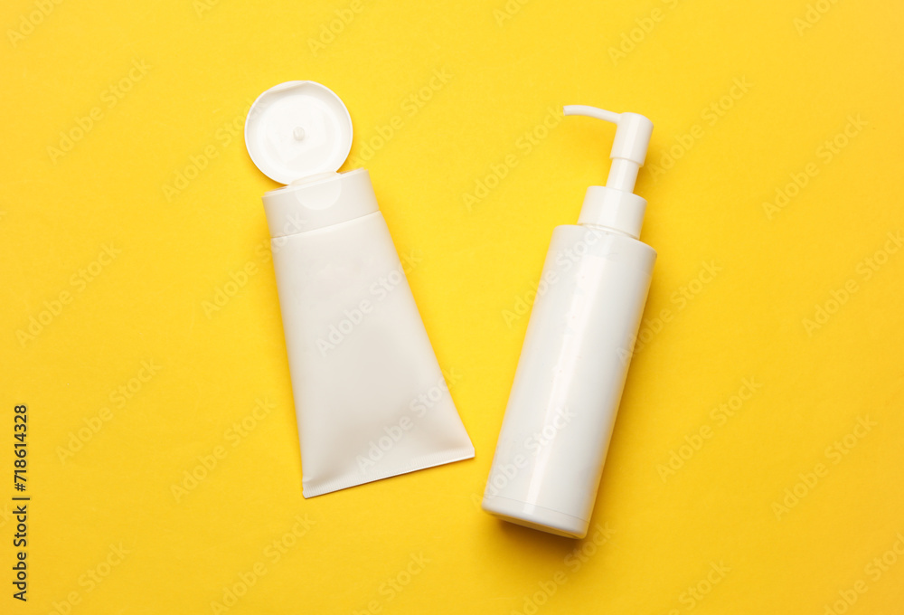 White bottles of cream on yellow background. Cosmetics