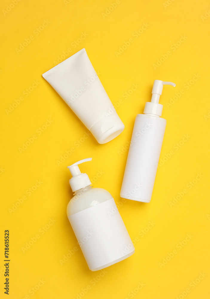 Cosmetics bottles on yellow background Cosmetics bottles on yellow background