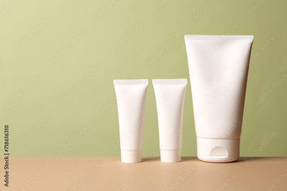 Cream tubes on a beige-green background Cream tubes on a beige-green background