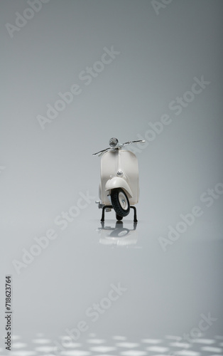 Photo of an old miniature Vespa which is also called a scooter. Photographed with a light background to isolate the white Vespa object