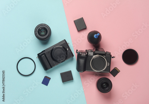 Two Modern mirrorless cameras with accessories on a blue-pink background. Professional photographer equipment. Top view. Flat lay