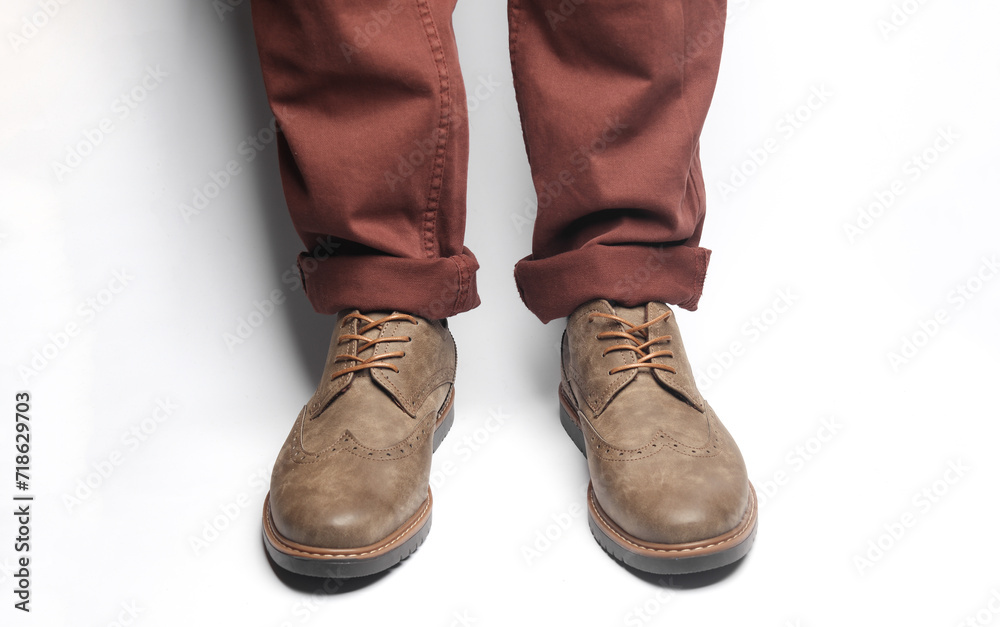 Male legs in brogue boots on a white background Male legs in brogue boots on a white background