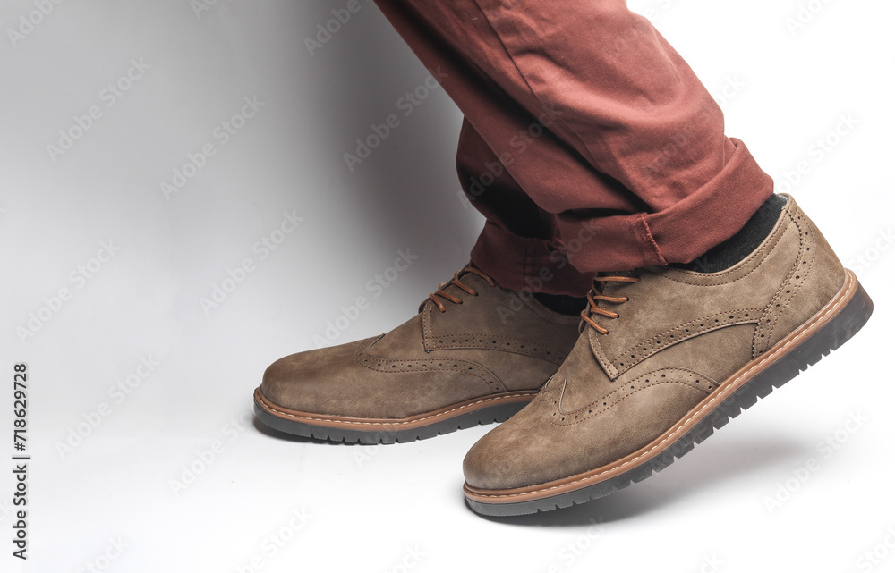 Male legs in brogue boots on a white background Male legs in brogue boots on a white background