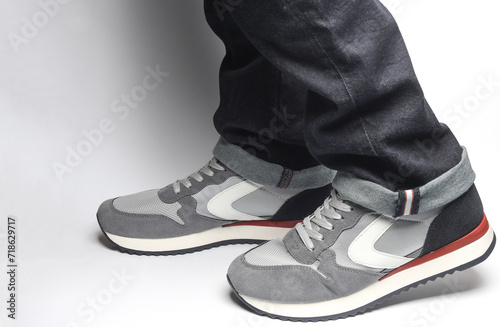 Male legs in jeans and sneakers on a white background © splitov27