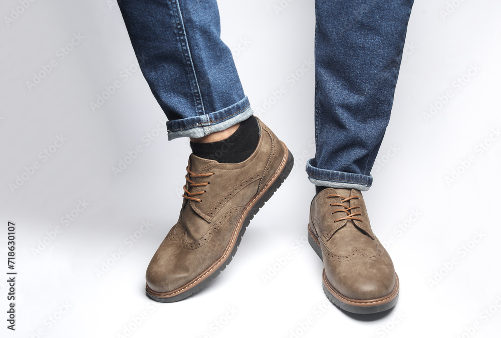Male legs in brogue shoes on a white background Male legs in brogue shoes on a white background