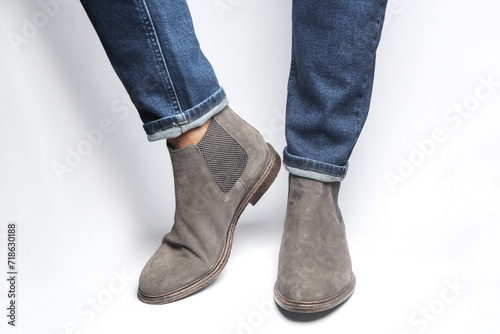 Man's legs in suede Chelsea boots on a white background