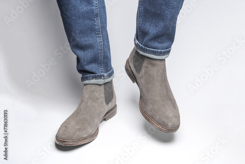 Man's legs in suede Chelsea boots on a white background