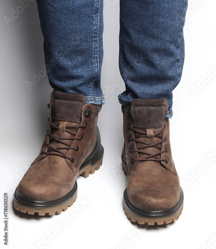 Male legs in jeans and warm winter boots on a white background