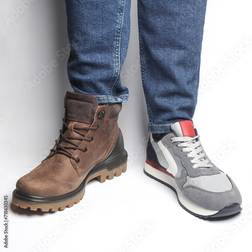 Male legs in different shoes on a white background