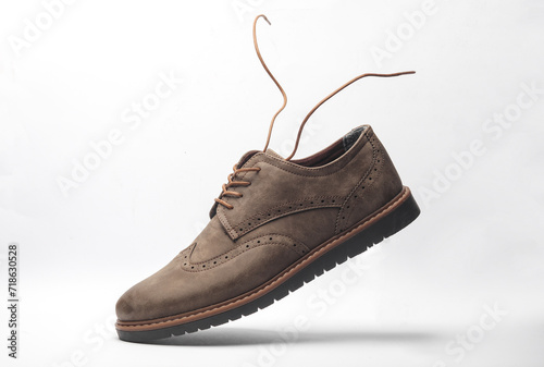 Leather brogue boot with flying laces on a white background