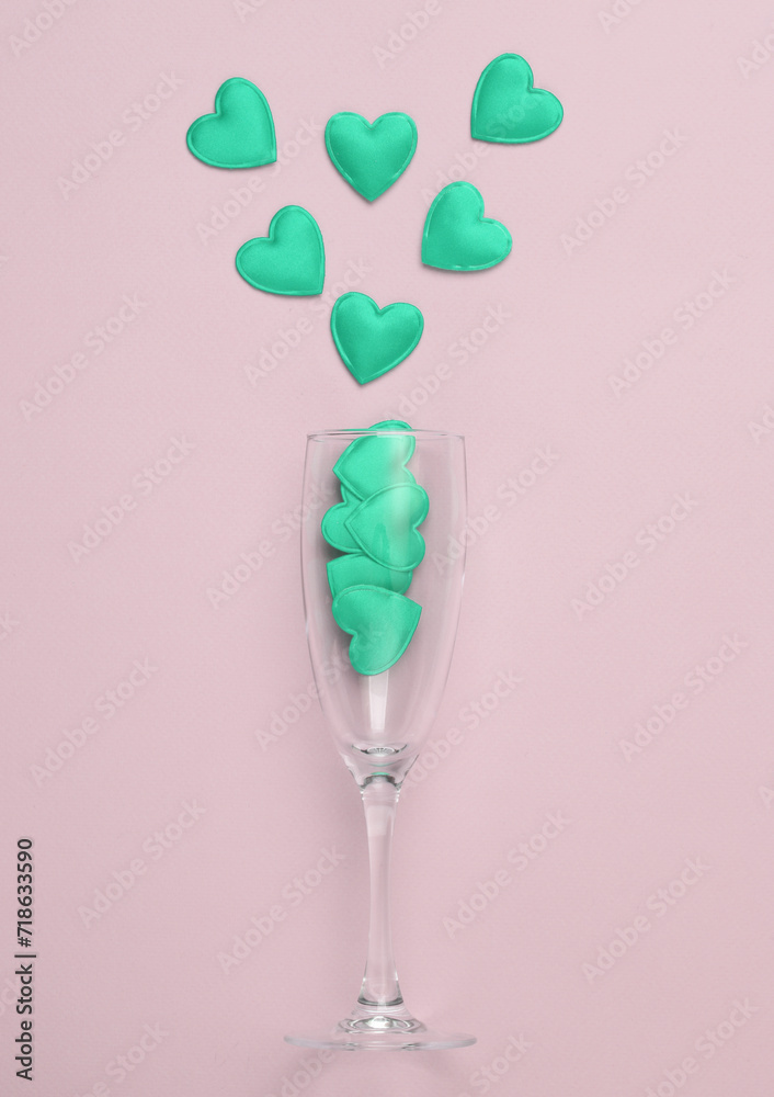 Glass with many green hearts on a pink background. Love, romantic concept, valentine's day