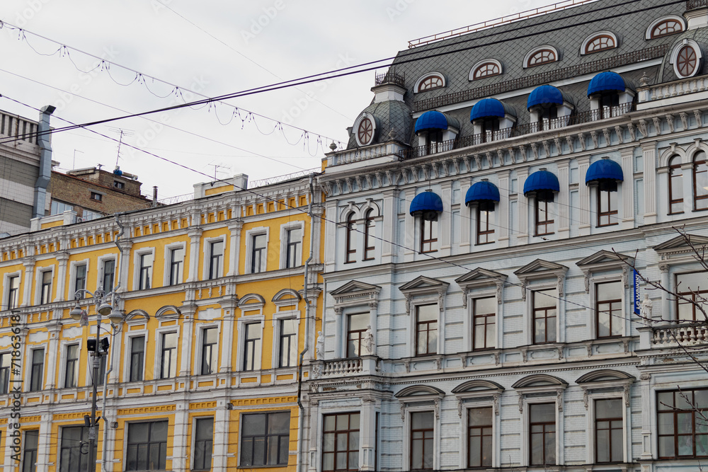Obraz premium KYIV, UKRAINE - JANUARY 19, 2024: very beautiful architecture in the city center. historical buildings of different colors in different districts. gloomy weather and snowy city. people are walking