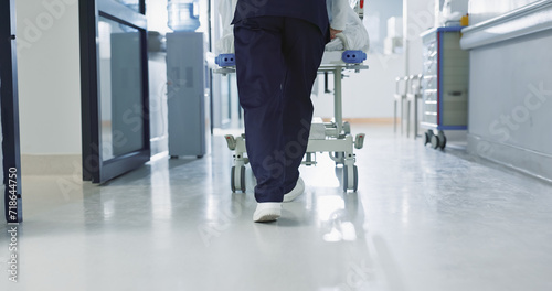 Nurse, feet and walking patient in hospital, bed or steps in hallway or corridor to surgery, operation room or ER healthcare. Doctor, moving and pushing person in clinic to ICU, bedroom or walk photo