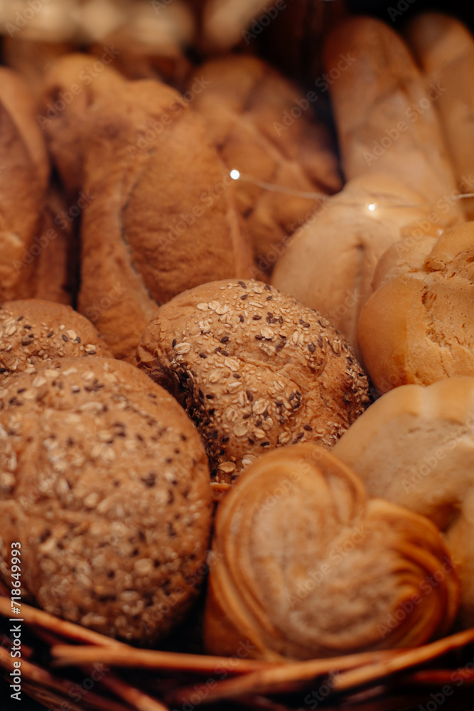 Fresh baked multigrain bread in a wicker basket in a baked goods store. Vertical shot