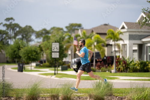 Running man sprinting workout outdoor. Fit athlete man running on american neighborhood. Sporty fit caucasian male, fitness sport model working out outside in full length.