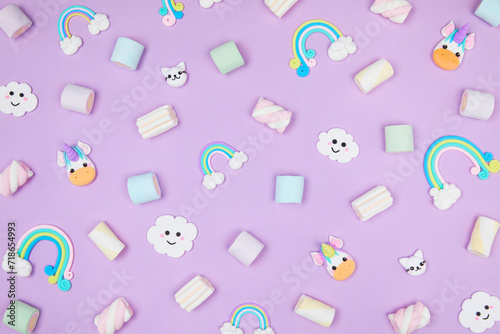 Trendy pastel purple kawaii background with cute air plasticine handmade cartoon animals, unicorns, clouds, rainbows, sweet marshmallows pattern. Top view, flat lay. Candycore, fairycore. photo