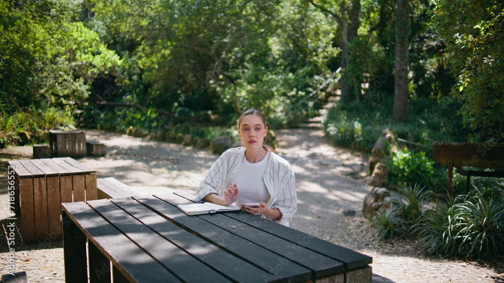 Fototapeta premium Attractive freelancer working forest table with notepad. Lady surfing online 