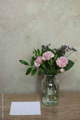 Bouquet of pink carnation flowers in a glass vase on the table