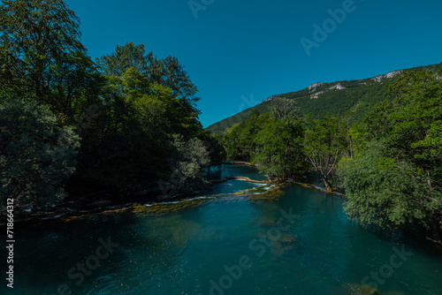Small waterfalls on Una river, close to Martin Brod, Bosnia, on a summer day. Beautiful green river in a valley, with cascades and small waterfalls flowing.