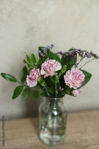 Bouquet of pink carnation flowers in a glass vase on the table © gabriela