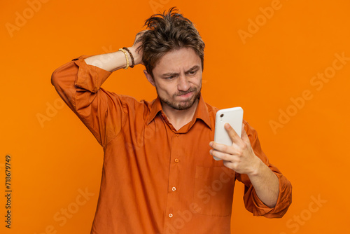 Obraz na plátně Upset sad Caucasian man use smartphone typing browsing, play game, loses, surprised by sudden lottery results bad fortune loss fail unlucky news