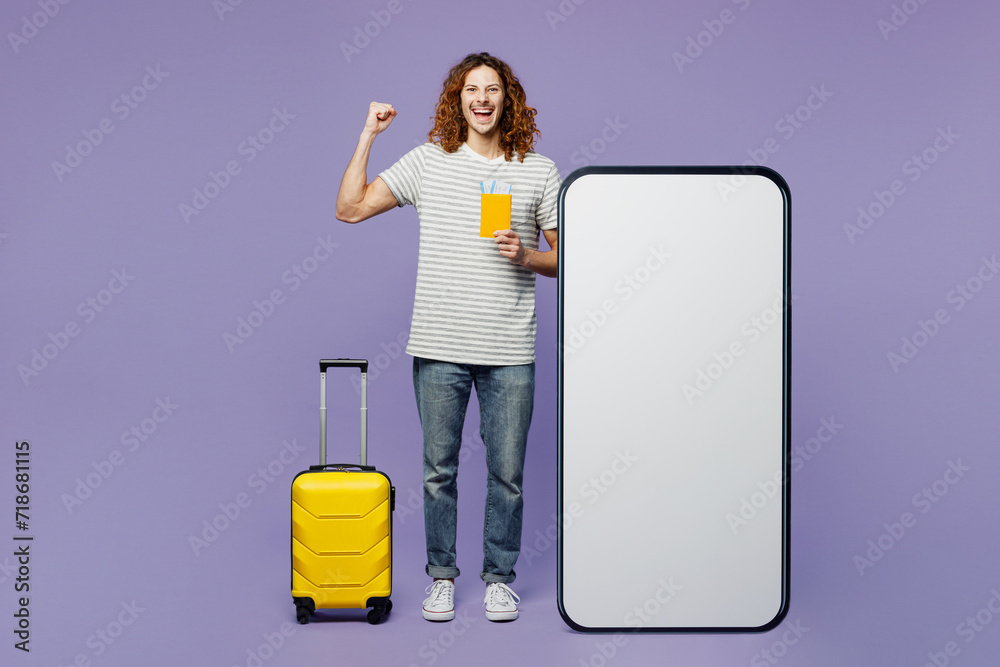 Traveler man wear casual clothes hold bag passport ticket blank screen mobile cell phone isolated on plain purple background. Tourist travel abroad in free time rest getaway. Air flight trip concept. Traveler man wear casual clothes hold bag passport ticket blank screen mobile cell phone isolated on plain purple background. Tourist travel abroad in free time rest getaway. Air flight trip concept.