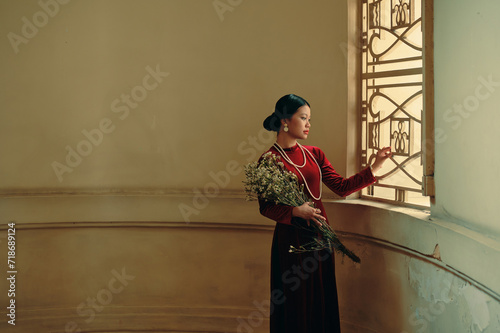 Portrait of young Vietnamese woman in red ao dai dress 