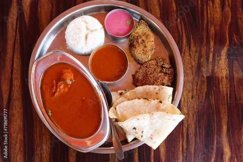 Malvani surmai fish Thali. It is a popular Indian or Konkani food platter that includes king fish or surmai curry, fish rava fry, Rice bhakri, Steamed Rice, Solkadhi, and salad. Copy space. photo