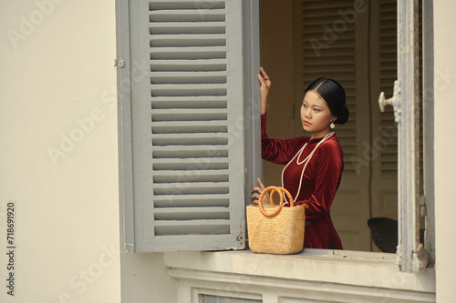 Portrait of young Vietnamese woman in red ao dai dress 
