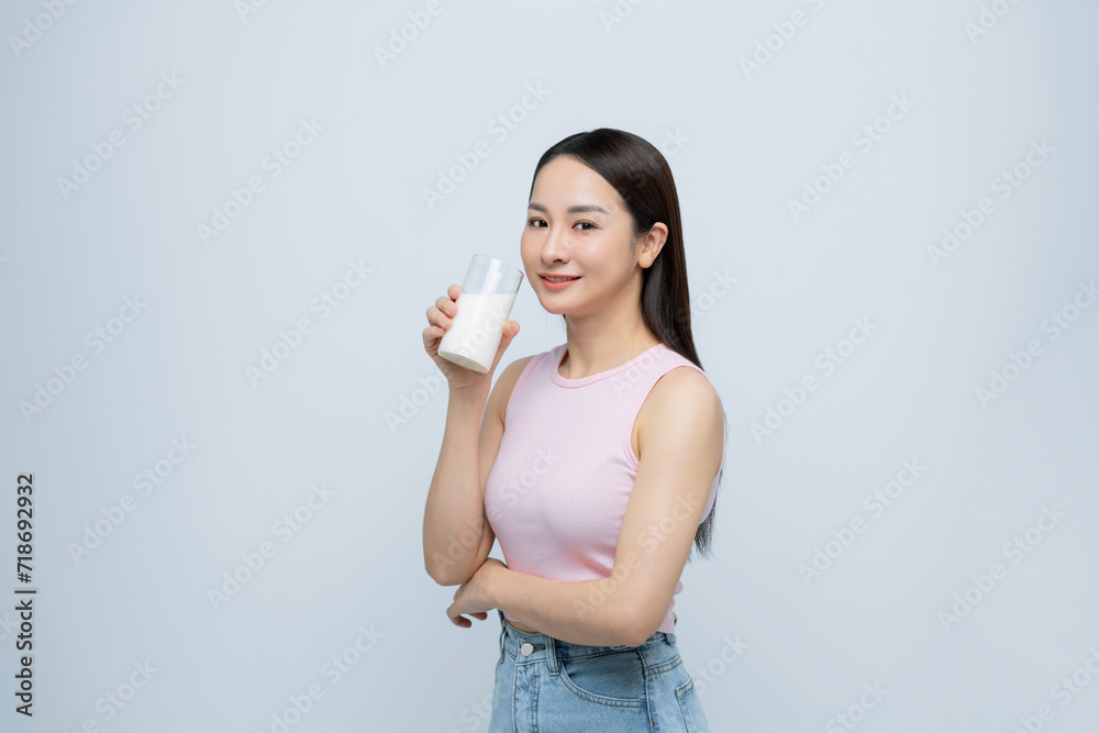 Young smiling happy fun woman hold in hand glass drink milk isolated on white background. Young smiling happy fun woman hold in hand glass drink milk isolated on white background.