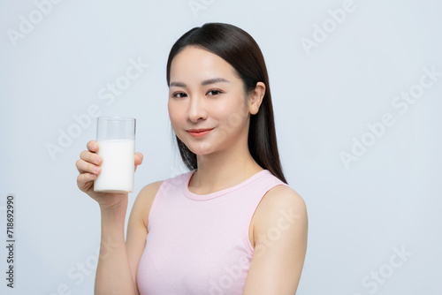 Young woman enjoying a glass of milk isolated over white background