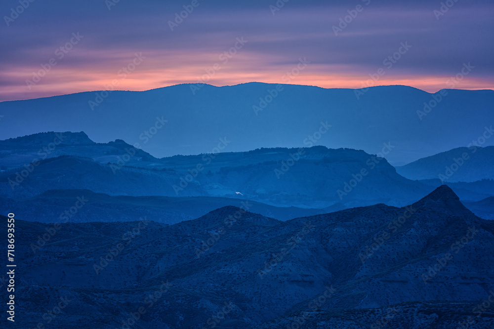 Twilight Hues over Layered Mountain Silhouettes
