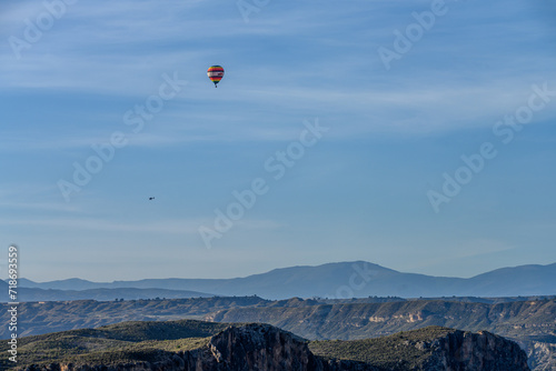 Hot Air Balloon Soaring Over Rugged Canyon Landscape