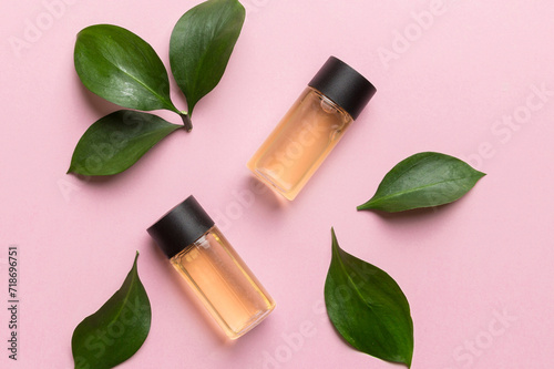 Organic cosmetic products with green leaves on color background. Flat lay
