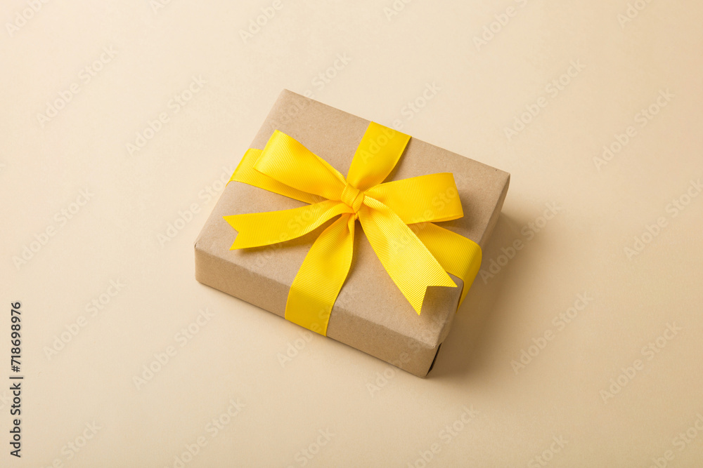 Wrapped christmas or other holiday handmade present in craft paper with colored ribbon. Present box, decoration of gift on table, top view with copy space Wrapped christmas or other holiday handmade present in craft paper with colored ribbon. Present box, decoration of gift on table, top view with copy space