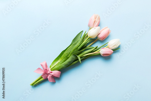 Bouquet of pink tulips on colored table background . Top view with copy space. Waiting for spring. Happy Easter card. Flat lay