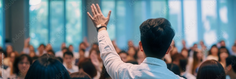 Man Raises Hands in Front of Crowd, Celebrating Achievement and Unity