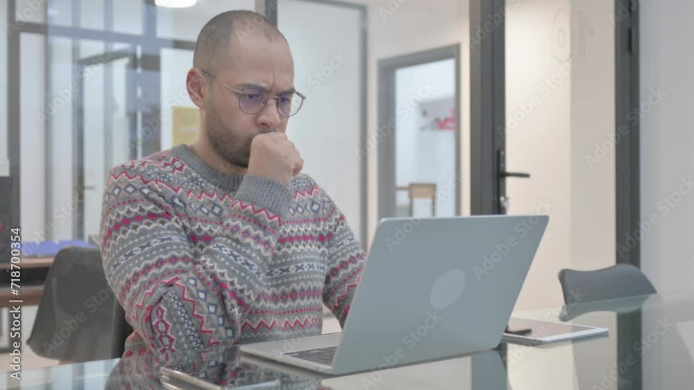 Coughing Young Hispanic Man Using Laptop