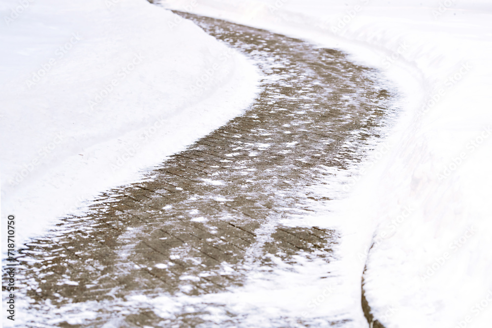 Snow removal work, cleared from snow sidewalk. Snow plow in the city, clean walkway. Cleared pedestrian curvy road after blizzard.  Snow clean work in the city. Selective focus