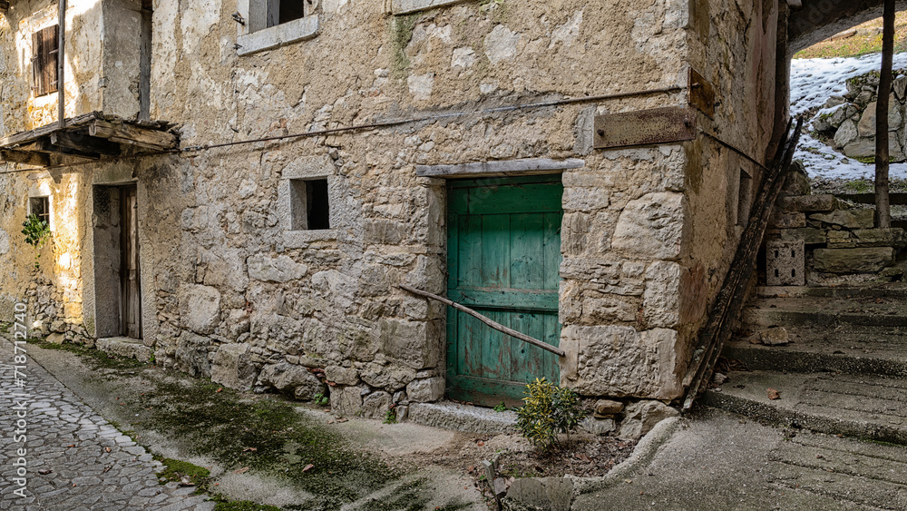 Ruins of traditional rural house facing on an alley of an almost abandoned Italian mountain village. Canalaz, Grimacco, Udine province, Friuli Venezia Giulia, Italy. Urbex photography.