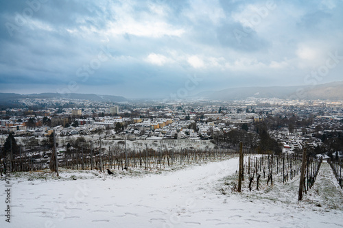 Vineyard with view of the ancient roman city of Trier covered in snow, Moselle Valley in Germany, winter landscape in rhineland palatine 