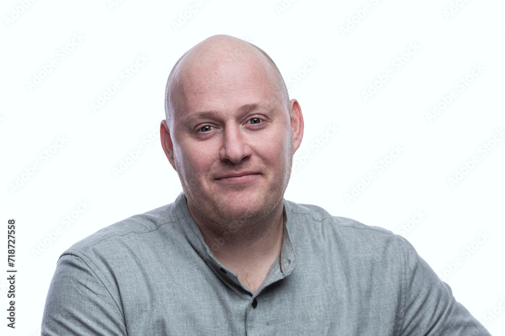 Smiling bald man in a gray shirt. Success and positivity. Isolated on a white background. Close-up. Smiling bald man in a gray shirt. Success and positivity. Isolated on a white background. Close-up.