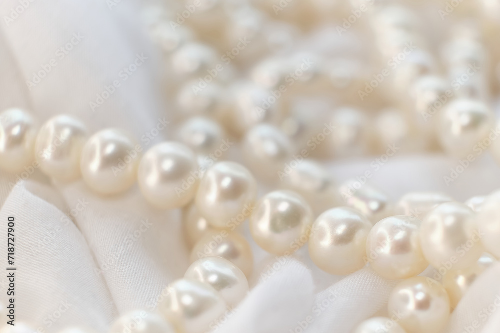 A string of natural pearls lay elegantly on a pale canvas, their soft focus creating a dreamy atmosphere. This image evokes a return to natural beauty amidst the modern era's harsh synthetic A string of natural pearls lay elegantly on a pale canvas, their soft focus creating a dreamy atmosphere. This image evokes a return to natural beauty amidst the modern era's harsh synthetic