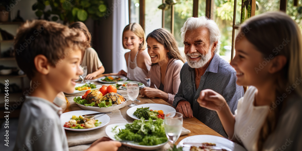 Happy extended family having fun while talking during lunch in dining room.