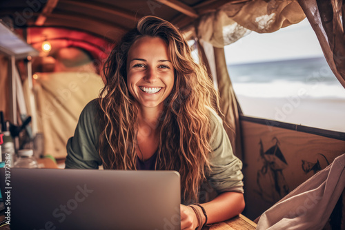 Happy digital nomad surfing the net on laptop in camper van.