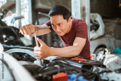 car mechanic using T socket to car engines parts for fixing © Odua Images