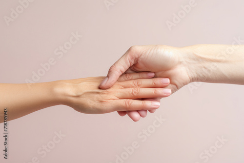 Old hand of elderly woman and young hand with youthful skin