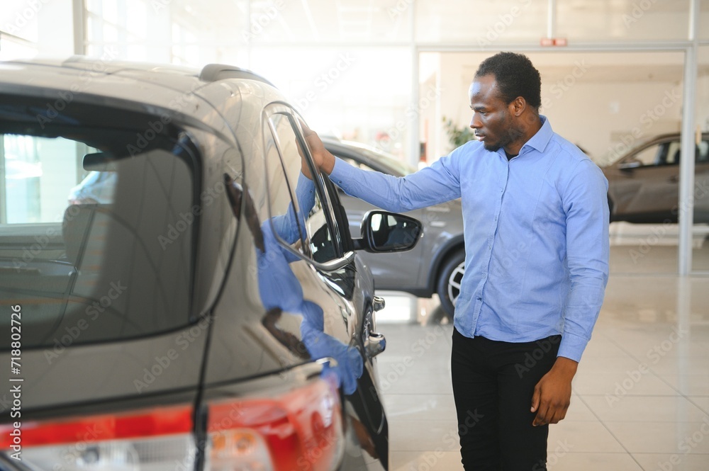 Car Buyer. Black Guy Choosing New Automobile In Dealership Store Car Buyer. Black Guy Choosing New Automobile In Dealership Store
